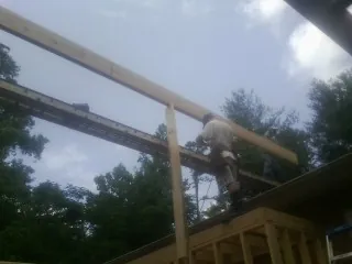 Carpenter setting a ridge beam over a new addition frame — Ice Dam Removal by Roofing Brothers in Sunman