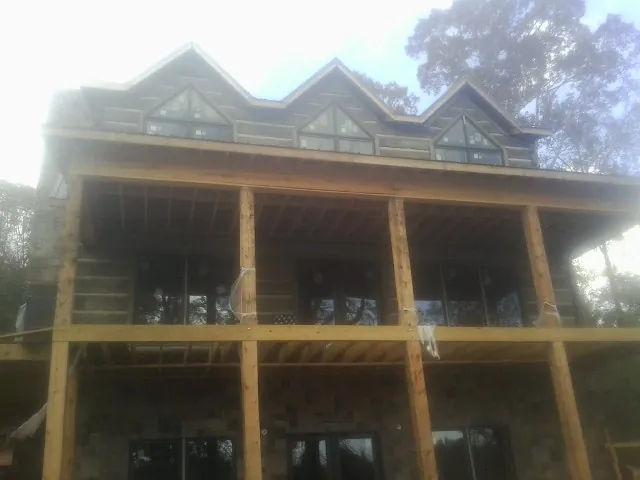Dormers and porch framing on a large log home under construction — Roof Coating work by our crew in Sunman