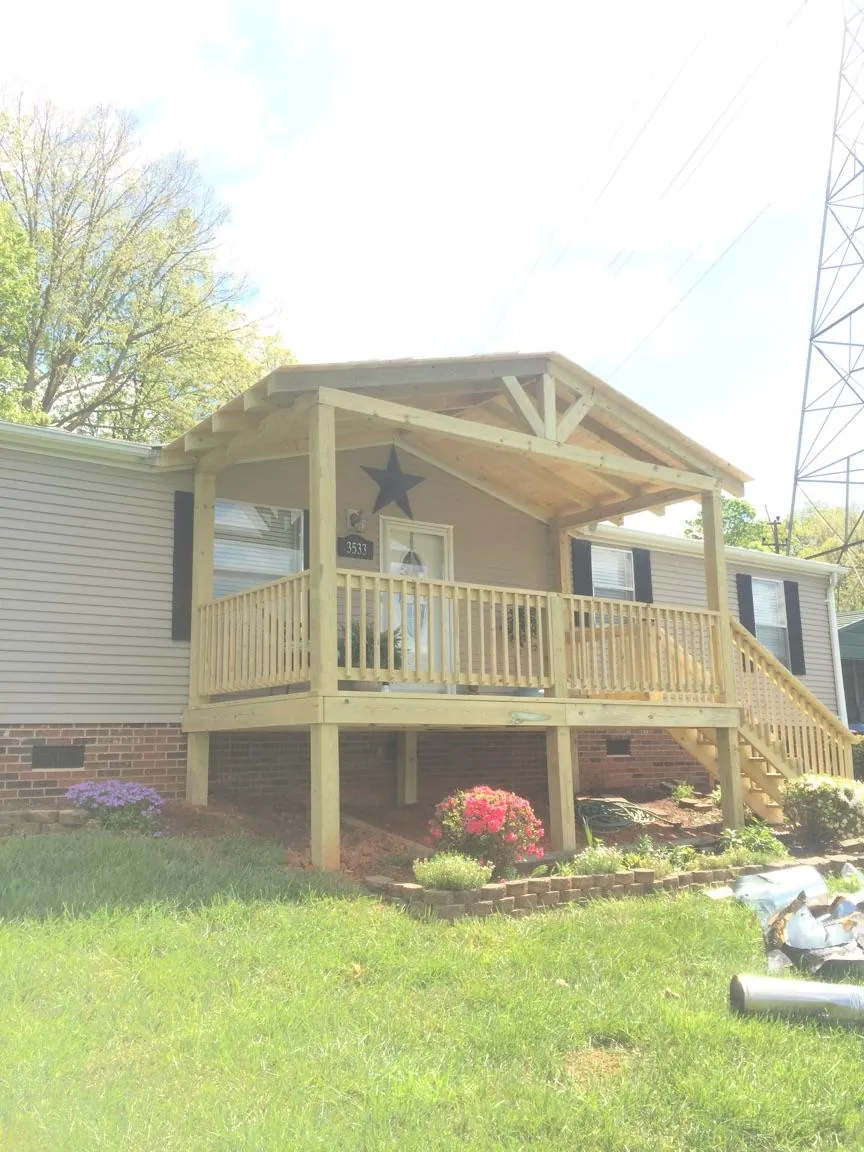 New gabled porch roof and deck railing added to a ranch home in Sunman